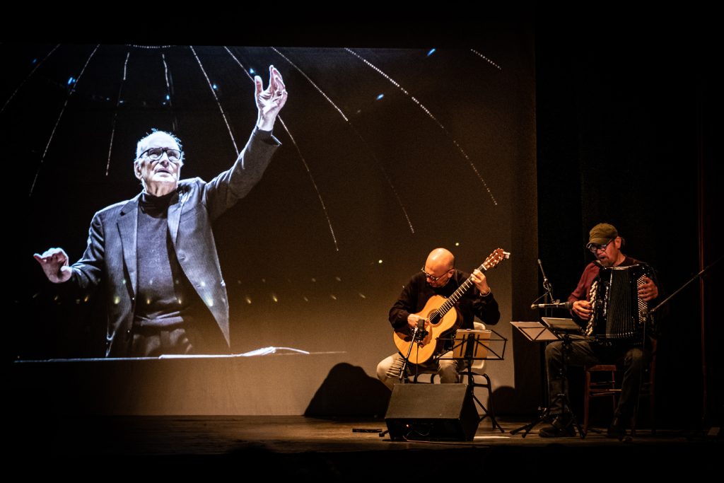 Viene rappresentato un musicista che suona la chitarra in omaggio a Ennio Morricone